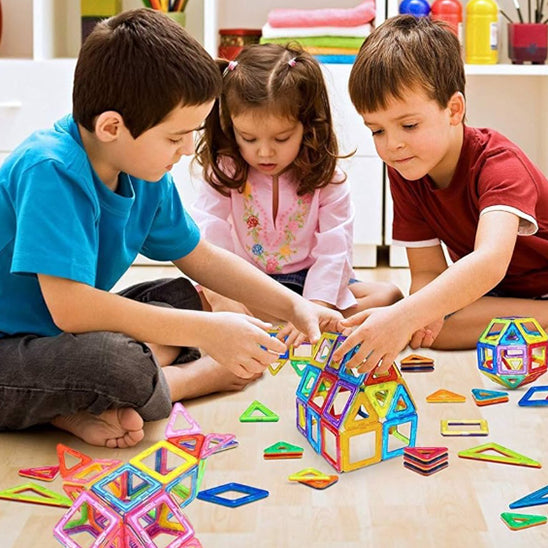trois enfants construisent maison avec jeu de construction magnétique