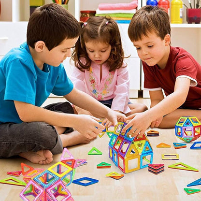 trois enfants construisent maison avec jeu de construction magnétique